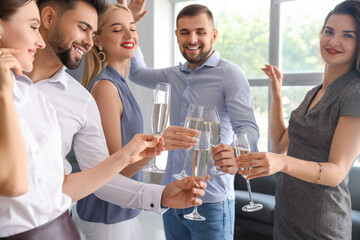 Young people drinking tasty champagne at party in office