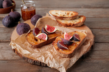 Tasty sandwiches with sweet fig jam on table
