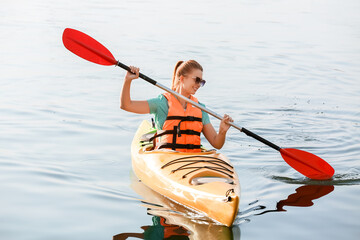 Young woman kayaking in river