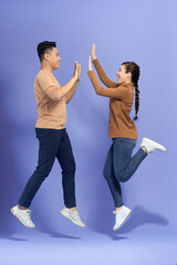 Young Man with Woman Jumping and Giving High Five