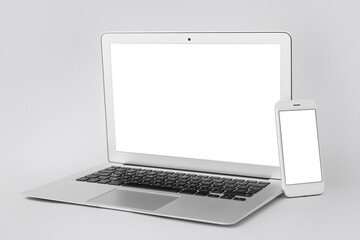 Fototapeta premium Modern laptop and mobile phone on grey background