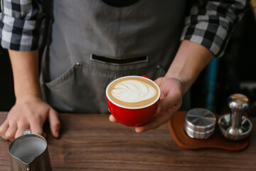 Barista making hot coffee in cafe, closeup