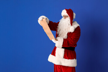 Santa Claus reading letter on color background