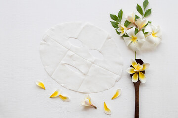 Fototapeta na wymiar natural sheet mask aroma for skin face from herbal flowers frangipani essence face mask on background white