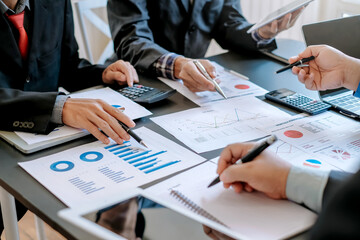 Business people brainstorm, discuss, plan and analyze business investment data graphs in meeting room.