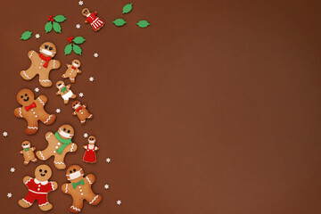 Merry christmas and happy new year greeting card with  gingerbread mask man cookies on brown background. Flay lay ,top view, copy space.マスクをつけたジンジャーマンクッキー