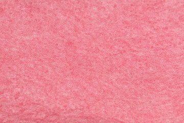 Fototapeta premium Fine grain pink matte background of suede fabric. Velvet texture of coral woolen felt.