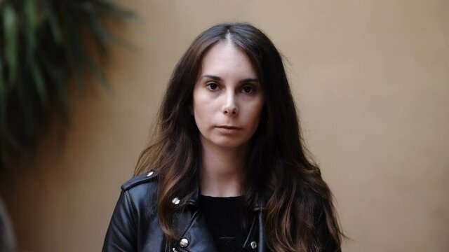 worries, thoughts - young concerned woman staring serious at camera