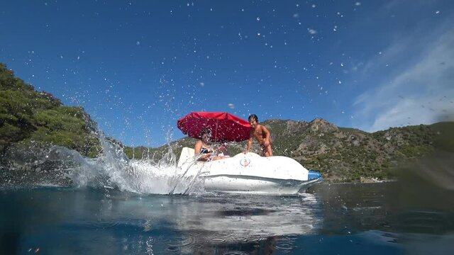 Oludeniz beach, Fethiye, Turkey - 24th of October 2020: 4K Children jump from the water bicycle in the Blue lagoon, above water and underwater shot
