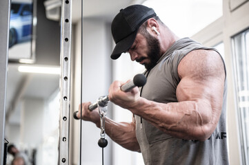 Fototapeta na wymiar strong bearded man with huge muscle lifting heavy weitht in sport gym during training workout leisure activity listening music in earpieces