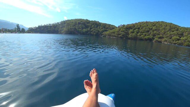Oludeniz beach, Fethiye, Turkey - 24th of October 2020: 4K Female feet and smooth surface of the Blue lagoon 
