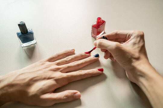 A Man Painting His Own Fingernails With Nail Polish