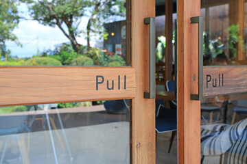 Fototapeta na wymiar Glass door of restaurant with text pull on wood.