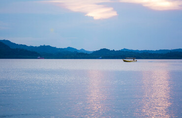 a sunset on the ocean with mountains
