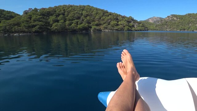 Oludeniz beach, Fethiye, Turkey - 24th of October 2020: 4K Womans feet and smooth surface of the Blue lagoon 
