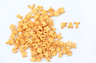 Heap of biscuit or cracker ABC letter alphabet with text FAT isolated on white background.
