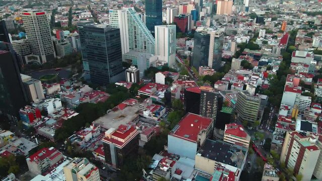Aerial view towards apartments, in front of skyscrapers in the financial district, during dusk, in Chapultepec, Mexico city, Central America - tilt down, drone shot