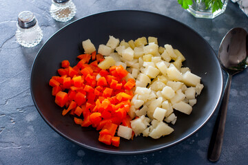 Step by step preparation of salad with red fish and vegetables, step 2 - slicing boiled potatoes and carrots, selective focus, horizontal