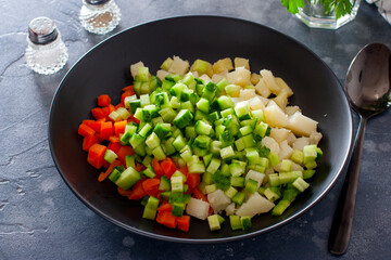Step by step preparation of salad with red fish and vegetables, step 3- adding sliced fresh cucumber to the salad, selective focus, horizontal