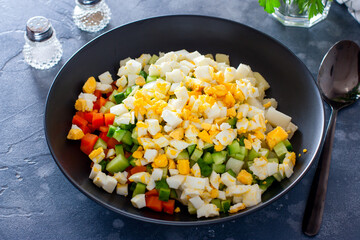 Step by step preparation of salad with red fish and vegetables, step 4 - adding sliced boiled egg to the salad, selective focus, horizontal