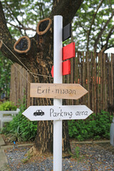 Direction parking area sign on wooden panel with arrow on the pole.
