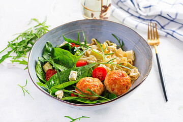 Italian pasta. Pasta  with meatballs,  cheese and fresh salad on light background. Dinner. Top view, overhead. Slow food concept