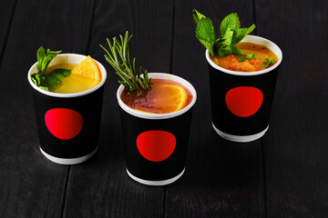 Three cargboard take away cups with fruit tea