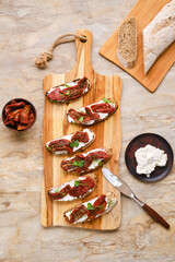 Top view of  toasts with goat cheese and dried tomato