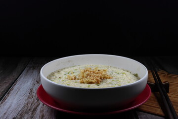 Steamed egg with mixed herbal vegetable on the bowl topping with deep fried garlic. Famous traditional breakfast menu in Asia restaurant. Soft and good for digestion food concept. 