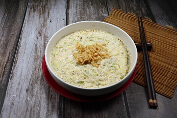 Steamed egg with mixed herbal vegetable on the bowl topping with deep fried garlic. Famous traditional breakfast menu in Asia restaurant. Soft and good for digestion food concept. 