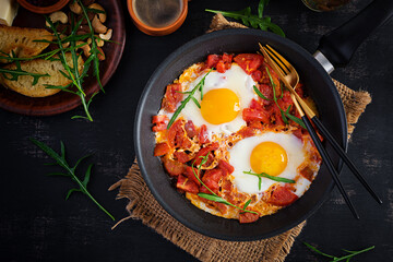 Late breakfast - fried eggs with vegetables. Shakshuka. Arabic cuisine. Kosher food. Top view