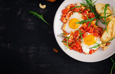 Late breakfast - fried eggs with vegetables. Shakshuka. Arabic cuisine. Kosher food. Top view