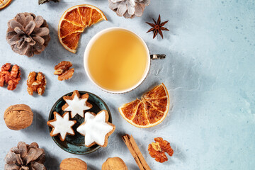 Christmas flat lay composition with tea, biscuits, spices, dried oranges, and a place for text, shot from above. Sustainable winter holidays concept