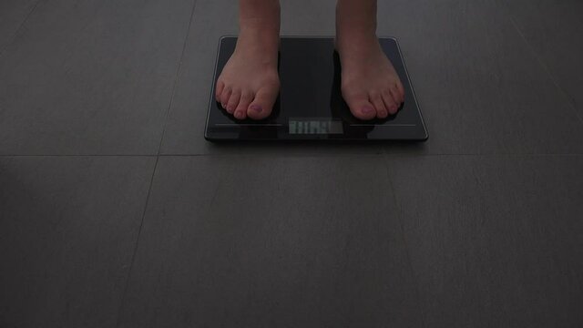 Adult woman measuring herself on a scale put weight.