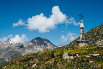 Obraz premium un calvaire dans les alpes. Paysage de montagnes avec un calvaire, des fleurs. Les alpes françaises.