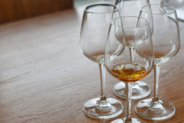 There is a glass of wine in the bottom of the glass. Put on the table, wood grain, brown
