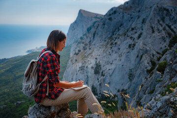 Naklejka premium woman hiker enjoy the view at sunset mountain peak cliff
