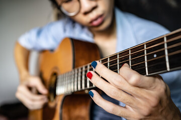 Fototapeta premium A man with polished nails playing guitar