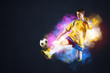 Soccer player kicking ball in colorful smoke