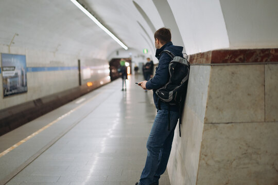 caucasian man wearing medicine mask leaning on wall of underground station while waiting for the train in saint petersburg, Russia. Image with selective focus