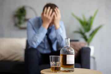 close up of whiskey bottle and glass, depressed and tired businessman with headache