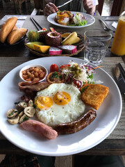 Healthy breakfast with eggs, sausagge, beans and tropical fruit as passion fruit, dragon fruit and mango, Vietnam