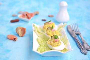 Cold appetizer, stuffed eggs with shrimps and pickled cucumber