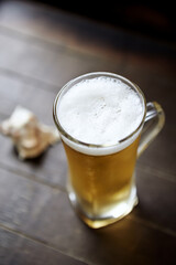 Glass of beer on dark wooden background.