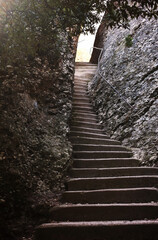 Difficult stone stairs going up to the light / beautiful view. Tracking and hiking. Success in business concept. Life path and coaching idea. 