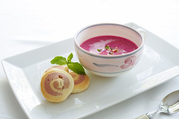Beet potage soup and beet cookies on white dish