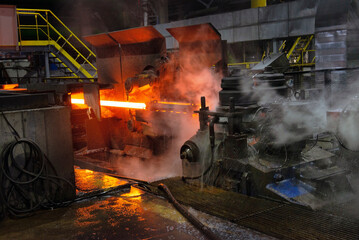 Fototapeta na wymiar hot steel on conveyor in a steel mill. hot rolled rebar