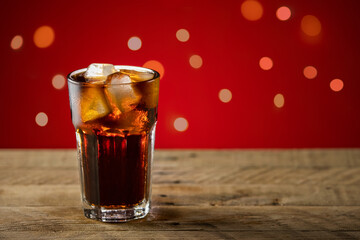 Soda on a wooden table with red background