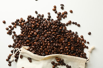 Bag with coffee seeds on white background