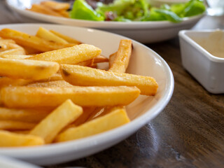 French fries are on a white plate. With copy space